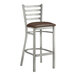 A Lancaster Table & Seating metal ladder back bar stool with a dark brown vinyl seat.