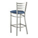 A Lancaster Table & Seating metal bar stool with a navy blue vinyl padded seat.
