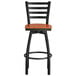 A Lancaster Table & Seating black ladder back swivel bar stool with a cherry wood seat.