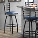 A Lancaster Table & Seating black bar stool with a navy blue padded seat and backrest.