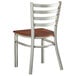 A Lancaster Table & Seating metal ladder back chair with a wooden seat.