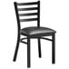 A Lancaster Table & Seating black metal ladder back chair with a black cushion.