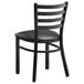 A Lancaster Table & Seating black metal ladder back chair with a black vinyl padded seat.