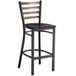 A black metal Lancaster Table & Seating bar stool with a black wooden seat.