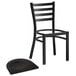 A Lancaster Table & Seating black metal ladder back chair with a black wood seat.