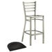 A Lancaster Table & Seating metal ladder back bar stool with black wood seat.