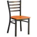 A Lancaster Table & Seating black and copper ladder back chair with a wooden seat.