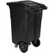 A black Toter rectangular trash can with wheels.