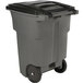 A grey Toter rectangular trash can with wheels and a black lid.