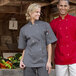 A man and woman standing next to each other in a kitchen, both wearing Uncommon Chef short sleeve chef coats.