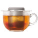 An OXO stainless steel tea infuser basket in a glass cup.