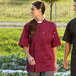 A woman and man in Uncommon Chef South Beach burgundy chef coats.