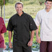 Three men wearing black Uncommon Chef short sleeve chef coats.