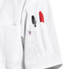 A white Uncommon Chef coat pocket with two red pens in it.