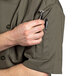 A man wearing an Uncommon Chef olive green chef coat with a pen in the pocket.