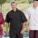 Three men wearing Uncommon Chef black short sleeve chef coats.