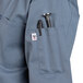 A blue Uncommon Chef short sleeve chef coat with a pocket and pen holder.
