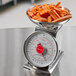A San Jamar kitchen scale with a bowl of carrots on it.