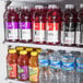 The open Avantco GDS-33-HCB refrigerator with shelves of bottled drinks.