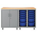 A natural wood rectangular worksurface on a grey storage unit with blue bins.
