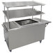 A stainless steel mobile serving cart with two shelves by Advance Tabco.