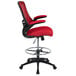 A red and black Flash Furniture mid-back drafting stool with flip-up arms.