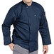 A man wearing a Uncommon Chef navy long sleeve chef coat.