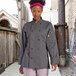 A woman wearing an Uncommon Chef Orleans long sleeve chef coat.