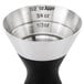 An OXO stainless steel double jigger with 1.5 and 1 oz. measurements on a counter.