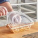 A person putting a pie in a Polar Pak clear plastic pie container.