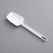 A white plastic spoon on a gray surface with a hole in the handle.