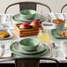 A table set with green American Metalcraft melamine bowls and plates.
