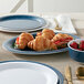 An American Metalcraft denim melamine platter on a table with croissants and strawberries.