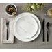 An American Metalcraft matte white melamine plate on a table with a fork.