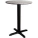 A round Lancaster Table & Seating dining table with a textured black base and white top.