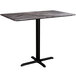 A Lancaster Table & Seating rectangular counter height table with a black metal base and a smooth black marble top.