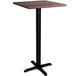 A Lancaster Table & Seating bar height table with a black base and a textured walnut top.