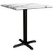 A Lancaster Table & Seating Excalibur dining height table with a marble top and cross base.