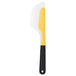An OXO white and yellow spatula with black accents.