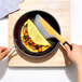 An OXO silicone spatula turning an omelet in a pan.