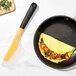 An OXO high heat flexible silicone omelet spatula turning an omelet in a pan.