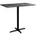 A Lancaster Table & Seating rectangular bar height table with a black metal base and a gray marble top.