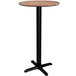 A Lancaster Table & Seating Excalibur round bar table with a wood top and black base.