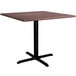 A Lancaster Table & Seating square dining table with a textured walnut top and black cross base.