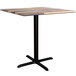 A Lancaster Table & Seating square table with a black cross base and wood top.