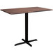 A rectangular brown table with a black cross base.