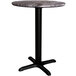 A Lancaster Table & Seating round dining table with a black metal base.