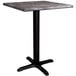 A Lancaster Table & Seating Excalibur square dining table with a black base and a marble top.