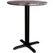 A Lancaster Table & Seating Excalibur round dining table with a black cross base.