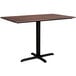 A Lancaster Table & Seating rectangular dining table with a textured walnut finish and a black metal cross base.